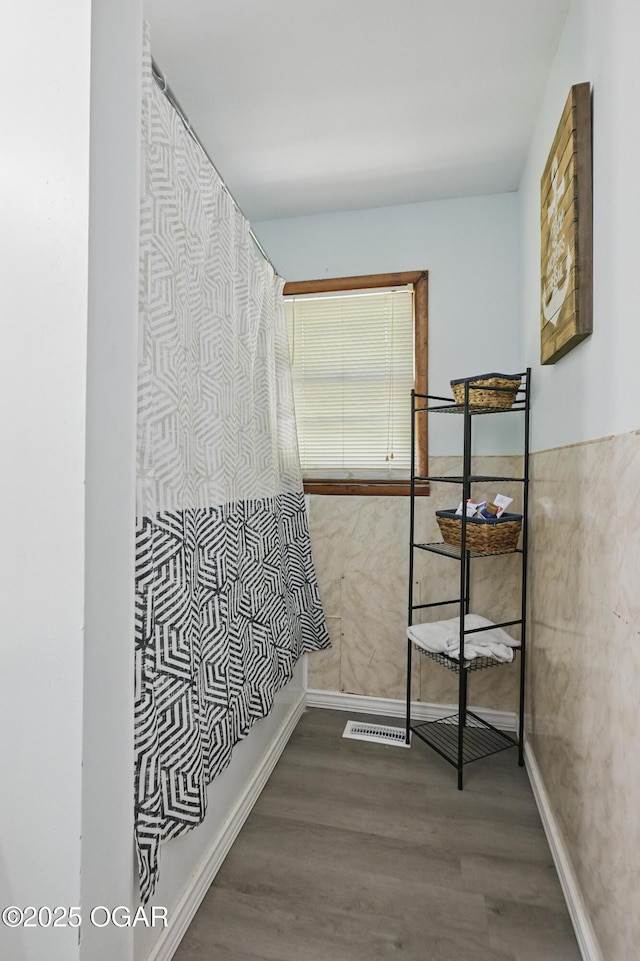 hall featuring wood finished floors and baseboards