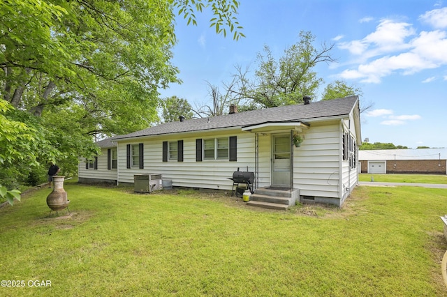 rear view of property with crawl space, a lawn, and a chimney