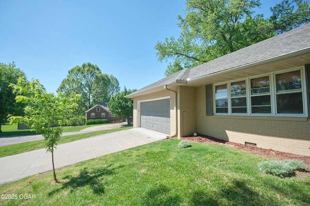 608 Sycamore Ln, Pittsburg, KS 66762 - view of home's exterior featuring a garage, brick siding, driveway, and a lawn