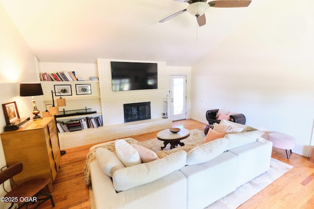 608 Sycamore Ln, Pittsburg, KS 66762 - living room featuring lofted ceiling, wood finished floors, a ceiling fan, and a fireplace