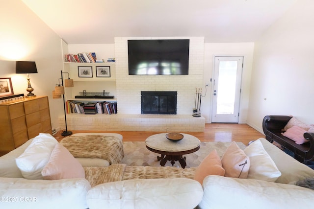 608 Sycamore Ln, Pittsburg, KS 66762 - living area featuring wood finished floors, a brick fireplace, and baseboards