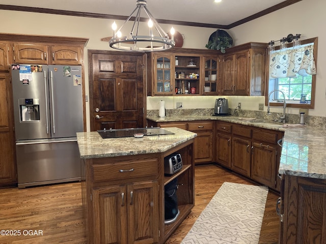 kitchen featuring stainless steel refrigerator with ice dispenser, open shelves, a chandelier, a sink, and crown molding