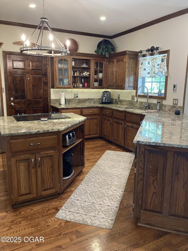 kitchen featuring open shelves, black electric cooktop, a sink, ornamental molding, and a chandelier