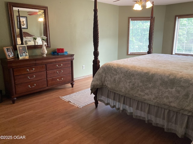 bedroom featuring wood finished floors, baseboards, and a ceiling fan