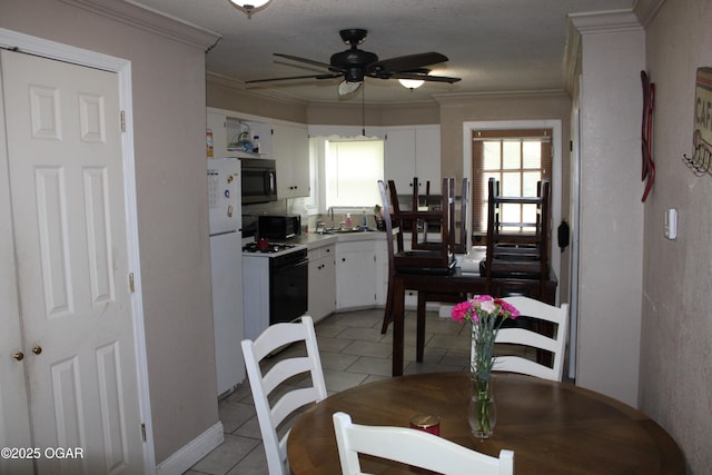 504 E Jackson St, Pittsburg, KS 66762 - dining room featuring a ceiling fan, crown molding, and light tile patterned floors