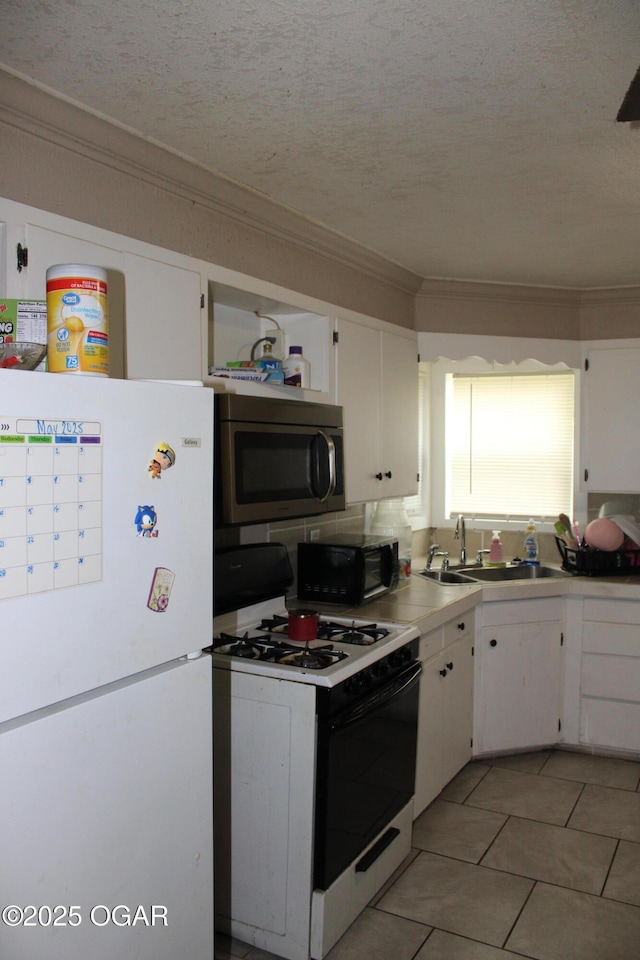504 E Jackson St, Pittsburg, KS 66762 - kitchen with freestanding refrigerator, range with gas cooktop, stainless steel microwave, a sink, and black microwave