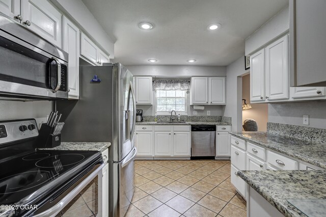 1912 N Duquesne Rd, Joplin, MO 64801 - kitchen with appliances with stainless steel finishes, a sink, white cabinets, light tile patterned floors, and recessed lighting