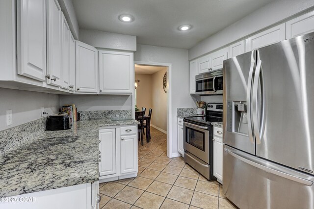 1912 N Duquesne Rd, Joplin, MO 64801 - kitchen with stainless steel appliances, light tile patterned floors, white cabinetry, recessed lighting, and baseboards
