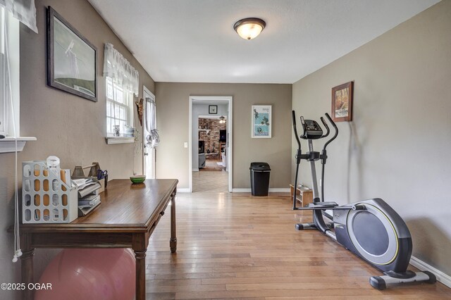 1912 N Duquesne Rd, Joplin, MO 64801 - workout area featuring light wood-style floors, baseboards, and a brick fireplace