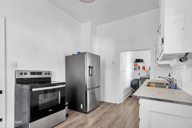 1815 S Empire Ave, Joplin, MO 64801 - kitchen featuring appliances with stainless steel finishes, light wood finished floors, light countertops, a sink, and white cabinetry