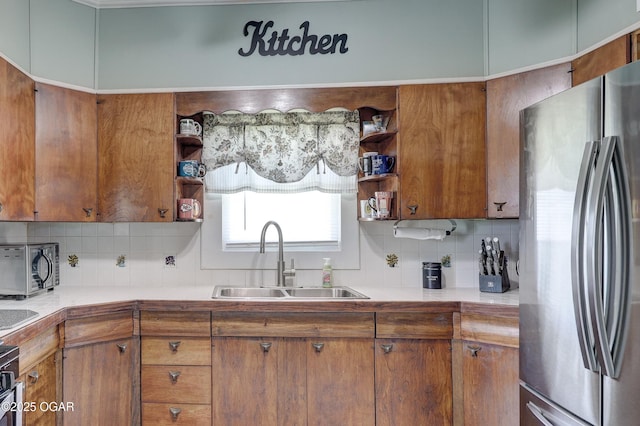 1712 E Broadway St, Joplin, MO 64801 - kitchen with freestanding refrigerator, a sink, open shelves, decorative backsplash, and brown cabinetry