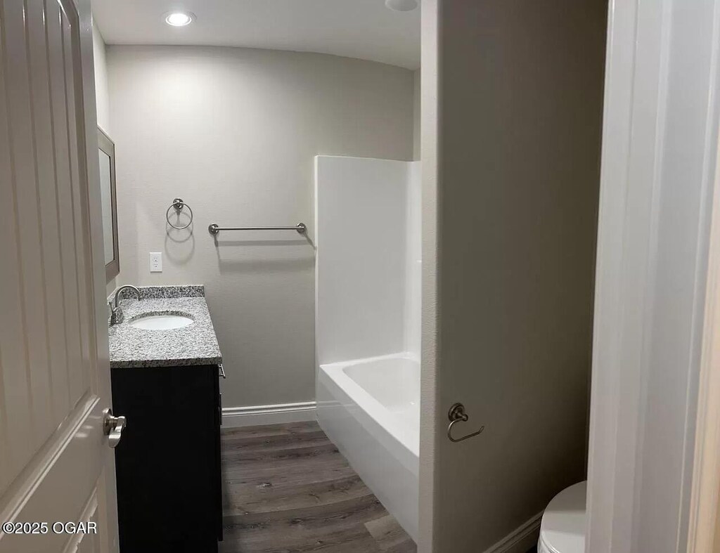 1403 E Valley St, Joplin, MO 64801 - bathroom with vanity, toilet, wood finished floors, recessed lighting, and baseboards
