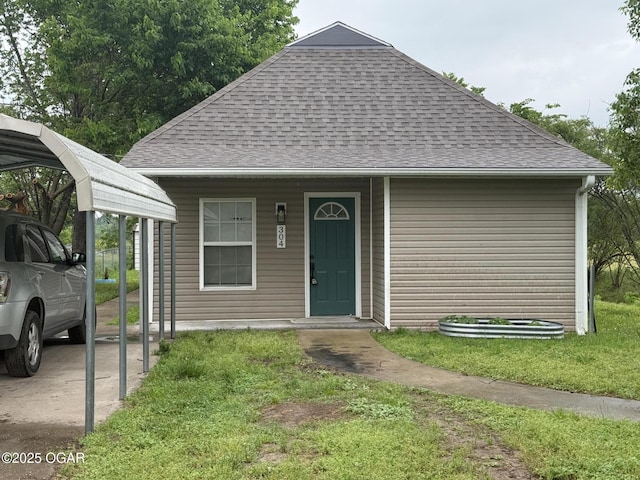 304 Market St, Wentworth, MO 64873 - view of front of house featuring roof with shingles, a carport, and a front yard