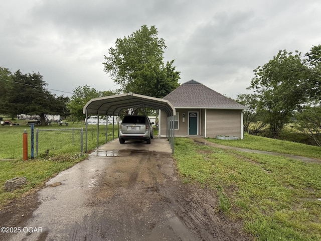 304 Market St, Wentworth, MO 64873 - view of front of house with a front lawn, a detached carport, driveway, and a shingled roof