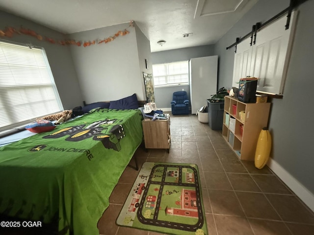 304 Market St, Wentworth, MO 64873 - bedroom featuring dark tile patterned floors, a barn door, and baseboards