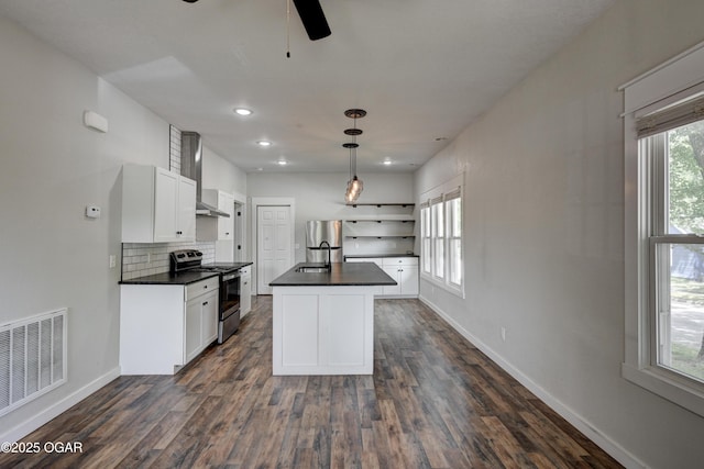 328 N Connor Ave, Joplin, MO 64801 - kitchen featuring appliances with stainless steel finishes, dark countertops, wall chimney range hood, dark wood finished floors, and recessed lighting