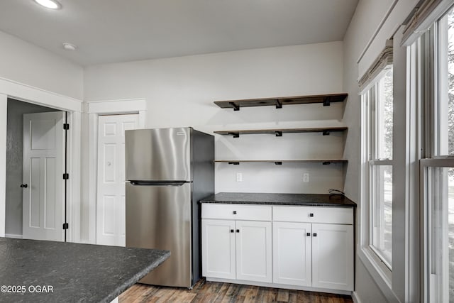 328 N Connor Ave, Joplin, MO 64801 - kitchen with freestanding refrigerator, open shelves, wood finished floors, white cabinetry, and dark stone counters