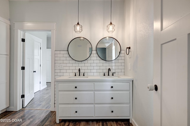 328 N Connor Ave, Joplin, MO 64801 - bathroom featuring backsplash, wood finished floors, double vanity, and baseboards