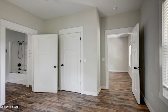 328 N Connor Ave, Joplin, MO 64801 - unfurnished bedroom featuring dark wood-type flooring, baseboards, and multiple windows