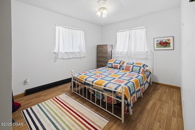 103 E Mockingbird Ln, Crane, MO 65633 - bedroom featuring multiple windows, wood finished floors, baseboards, and a ceiling fan