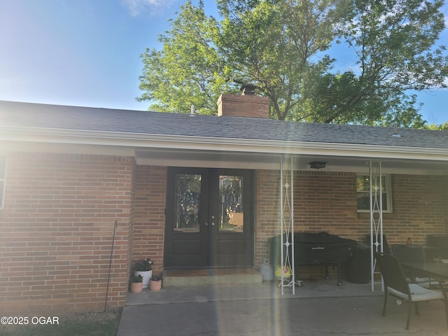 511 3rd St, Mccune, KS 66753 - entrance to property with french doors, brick siding, a chimney, and a patio