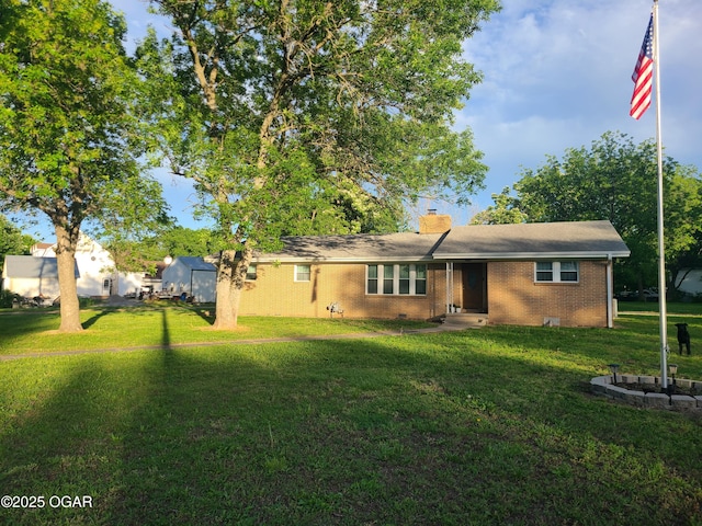 511 3rd St, Mccune, KS 66753 - view of front of house featuring a front yard, a chimney, and brick siding