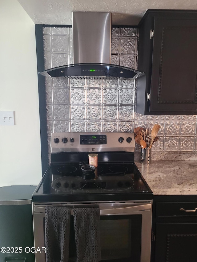 511 3rd St, Mccune, KS 66753 - kitchen with stainless steel electric stove, wall chimney exhaust hood, backsplash, and dark cabinets