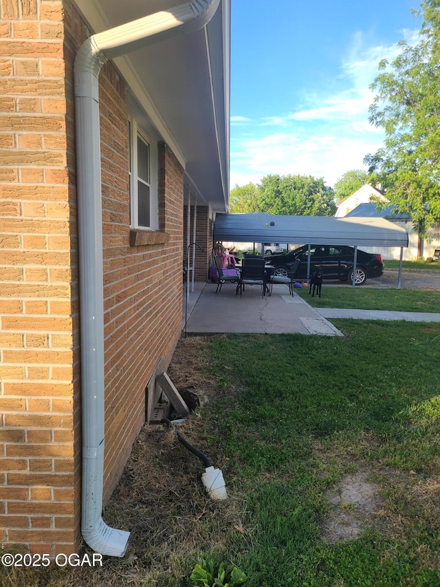 511 3rd St, Mccune, KS 66753 - view of side of home with brick siding, a patio area, and a lawn