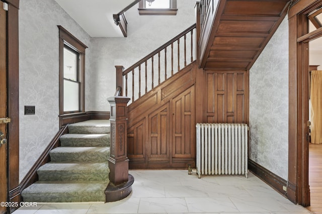 524 W 5th St, Joplin, MO 64801 - staircase with radiator, healthy amount of natural light, marble look tile flooring, and wallpapered walls