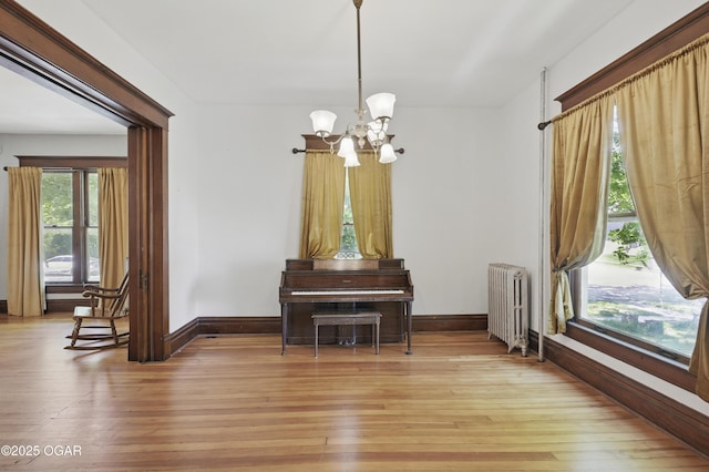 524 W 5th St, Joplin, MO 64801 - dining room with radiator, a chandelier, baseboards, and light wood-type flooring