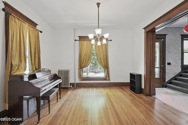 524 W 5th St, Joplin, MO 64801 - dining space featuring radiator, a chandelier, hardwood / wood-style floors, baseboards, and stairway
