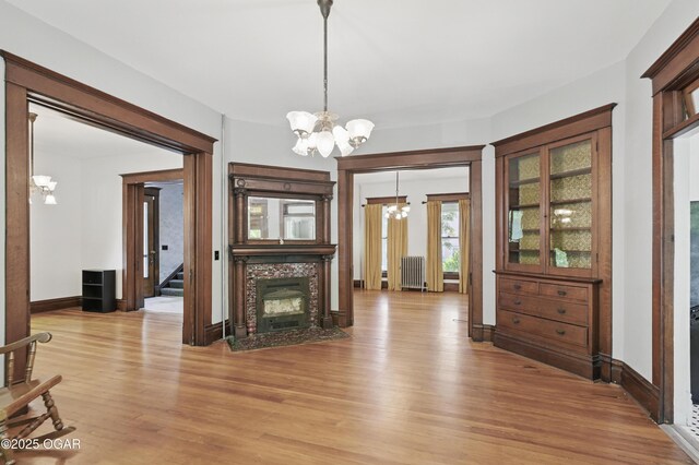 524 W 5th St, Joplin, MO 64801 - dining area featuring a chandelier, light wood-style floors, radiator, a fireplace, and stairs