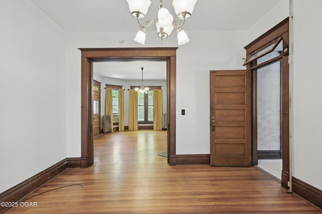 524 W 5th St, Joplin, MO 64801 - unfurnished dining area with a chandelier, baseboards, and wood finished floors
