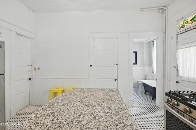 524 W 5th St, Joplin, MO 64801 - bedroom featuring a wainscoted wall, light floors, and connected bathroom