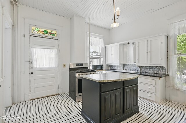 524 W 5th St, Joplin, MO 64801 - kitchen featuring gas range, light floors, white cabinets, a center island, and decorative light fixtures