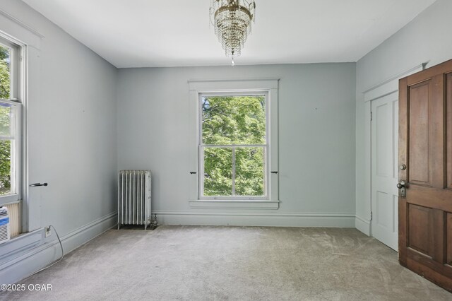 524 W 5th St, Joplin, MO 64801 - empty room with radiator, light carpet, a chandelier, and baseboards