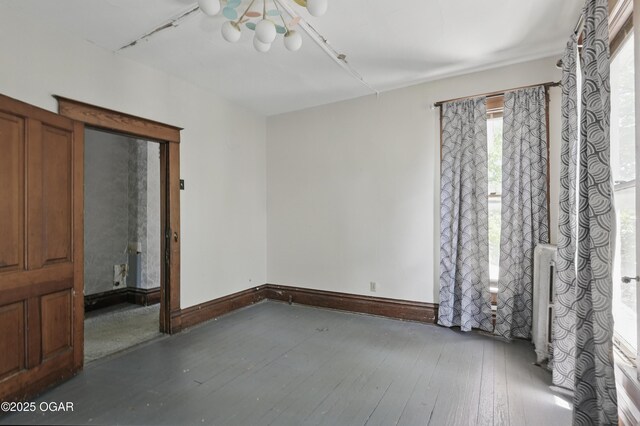 524 W 5th St, Joplin, MO 64801 - spare room featuring hardwood / wood-style floors, a chandelier, and baseboards