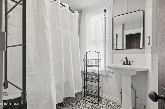 524 W 5th St, Joplin, MO 64801 - bathroom with tile patterned flooring, tile walls, a textured ceiling, and curtained shower
