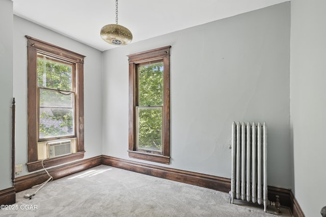 524 W 5th St, Joplin, MO 64801 - carpeted empty room featuring radiator heating unit, healthy amount of natural light, baseboards, and cooling unit