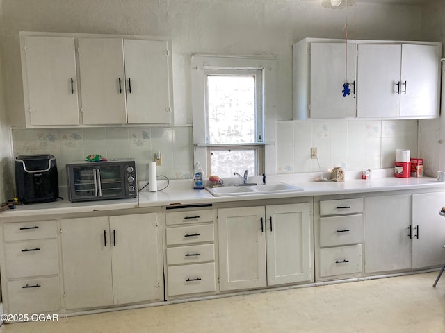 1017 E Broadway St, Joplin, MO 64801 - kitchen featuring a sink, decorative backsplash, and light countertops
