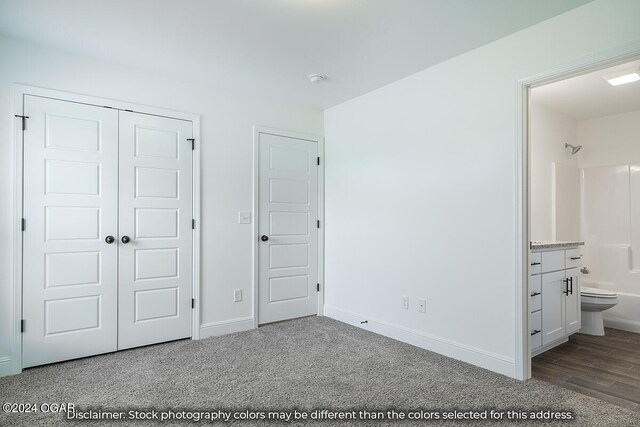 1507 E White Oak St, Joplin, MO 64801 - unfurnished bedroom featuring a closet, baseboards, ensuite bath, carpet, and wood finished floors