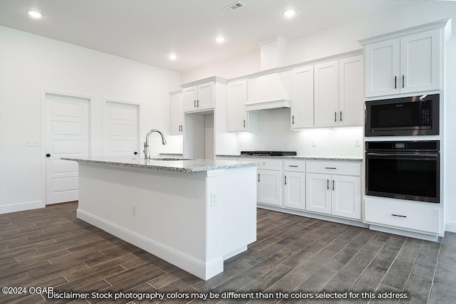 1507 E White Oak St, Joplin, MO 64801 - kitchen featuring oven, stainless steel microwave, wood finish floors, white cabinetry, and a sink