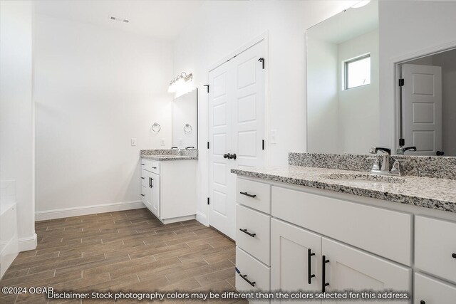 1507 E White Oak St, Joplin, MO 64801 - full bath featuring wood finished floors, baseboards, and two vanities
