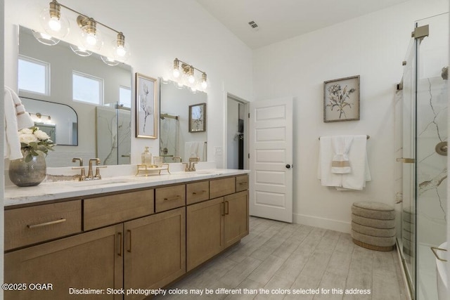 1713 E White Oak St, Joplin, MO 64801 - bathroom featuring a marble finish shower, wood finished floors, double vanity, and baseboards