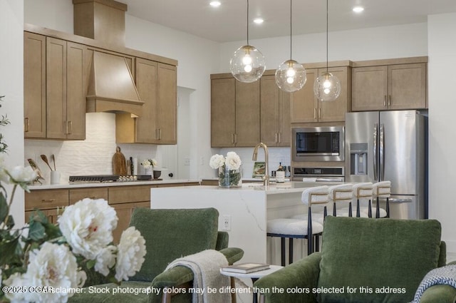 1713 E White Oak St, Joplin, MO 64801 - kitchen with appliances with stainless steel finishes, custom exhaust hood, decorative backsplash, hanging light fixtures, and a kitchen island with sink