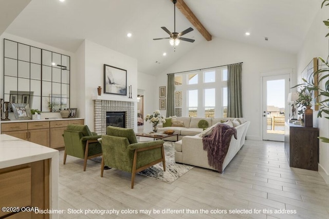 1713 E White Oak St, Joplin, MO 64801 - living area with high vaulted ceiling, beamed ceiling, a fireplace, a ceiling fan, and light wood-style floors