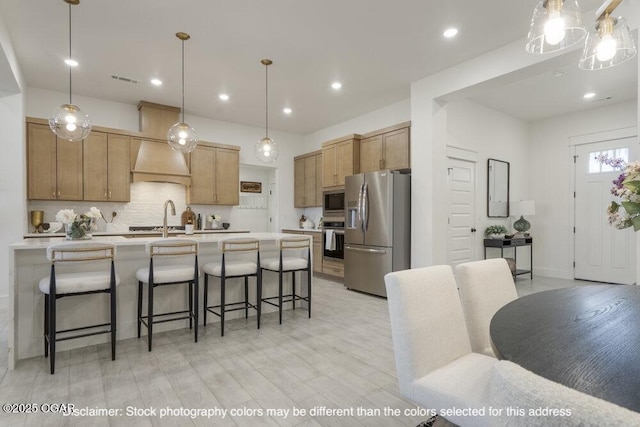 1713 E White Oak St, Joplin, MO 64801 - kitchen with stainless steel refrigerator with ice dispenser, built in microwave, custom exhaust hood, a breakfast bar area, and light countertops