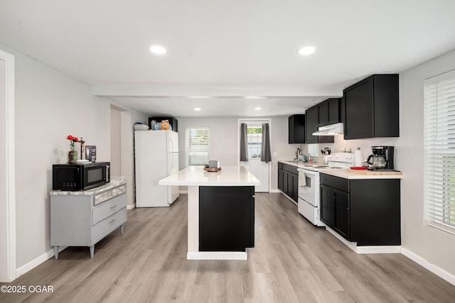 201 S Tom, Webb City, MO 64870 - kitchen with white appliances, dark cabinets, under cabinet range hood, light countertops, and light wood-type flooring