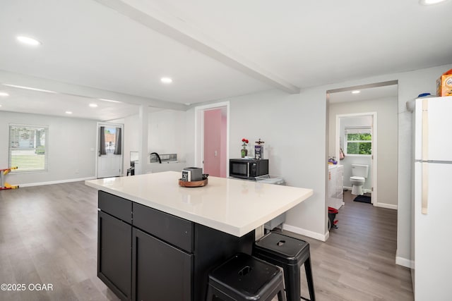 201 S Tom, Webb City, MO 64870 - kitchen featuring freestanding refrigerator, black microwave, recessed lighting, light wood-style flooring, and a breakfast bar area