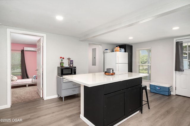 201 S Tom, Webb City, MO 64870 - kitchen with black microwave, freestanding refrigerator, light countertops, light wood-style floors, and recessed lighting